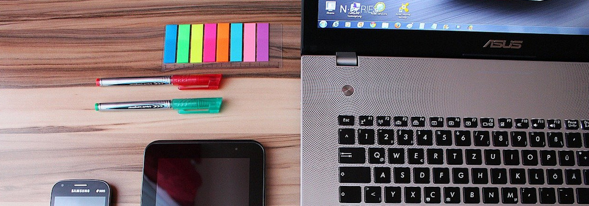 Das Bild zeigt einen Laptop, Stifte und Notizzettel