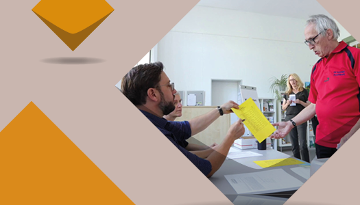 Blick in den Wahlraum – ein Wähler bekommt seine Wahlunterlagen ausgehändigt