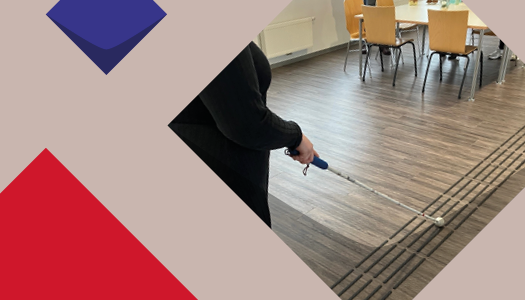 Eine Frau läuft in deinem Raum mit einem Blindenstock über einen Leitstreifen