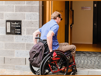 Ein Rollstuhlfahrer vor einer breiten Tür ohne Stufen; Bild: Andi Weiland I Gesellschaftsbilder