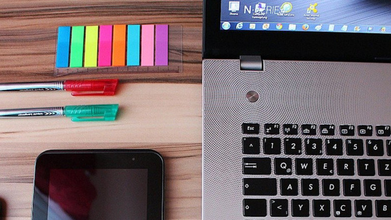 Das Bild zeigt einen Laptop, Stifte und Notizzettel