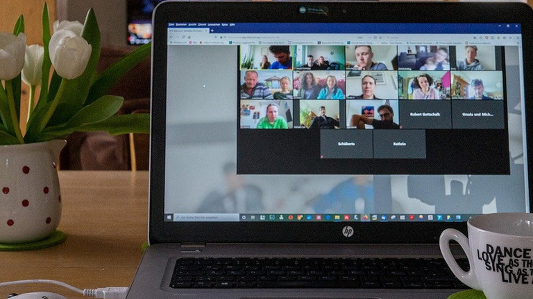 Das Bild zeigt einen Laptop mit einer Videokonferenz.