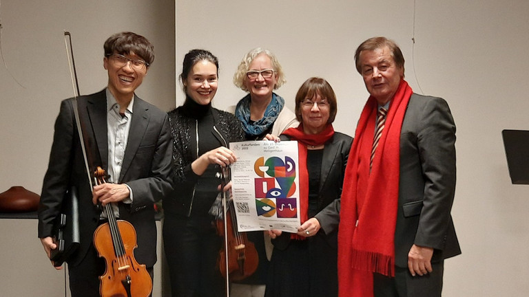 Foto der Violinisten Valentina Resnyanska und Andy Chen, dazu Iris Colsman und Margit Benemann vom KSL und der stellvertretende Bürgermeister Edmund Mathey