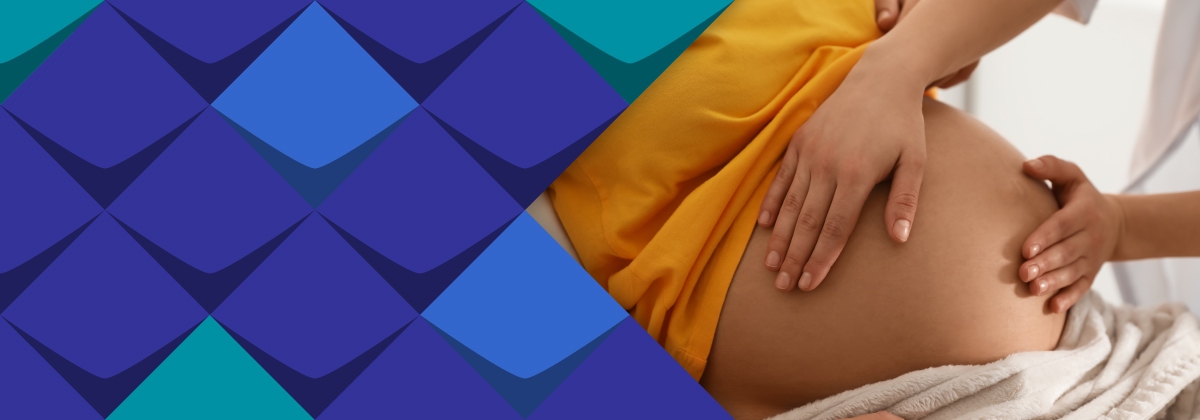 Eine Hebamme tastet den Bauch einer Schwangeren ab. 