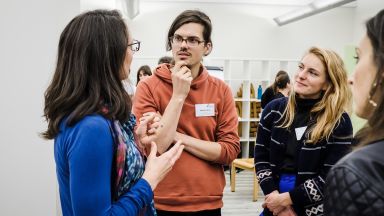 Das Foto zeigt vier Personen, die sich unterhalten. 