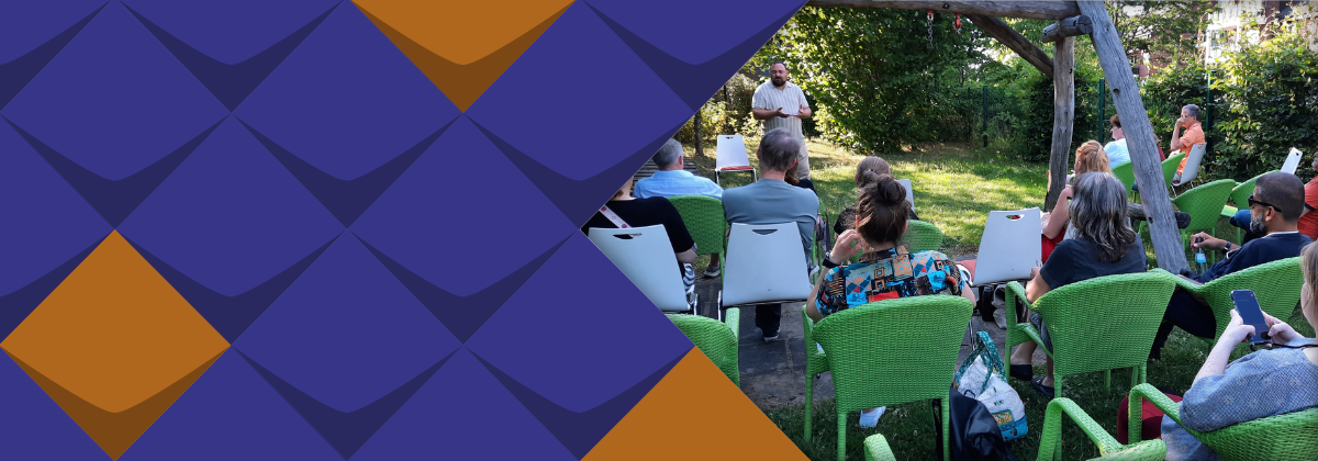 Rechtsanwalt Björn Jennert (vorne links) und Zuhörer*innen im Garten der Kita "Die kleinen Holzwürmer" in Solingen