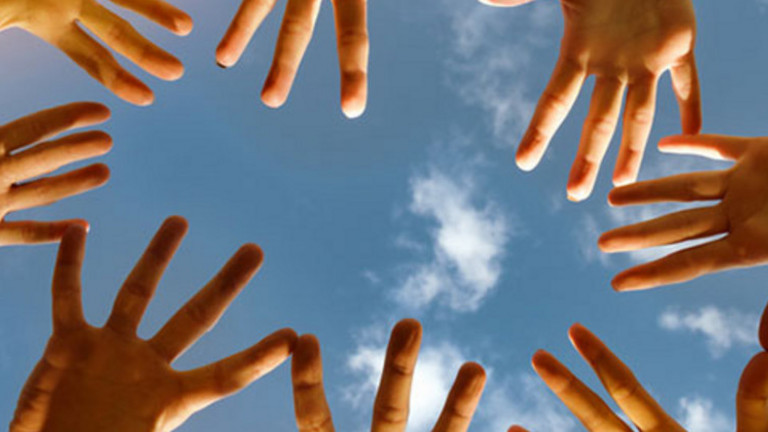 Das Bild zeigt mehrere Hände, im Hintergrund ist ein blauer Himmel.