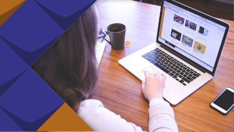 Eine junge Frau sitzt an einem Tisch und arbeitet an einem Laptop.