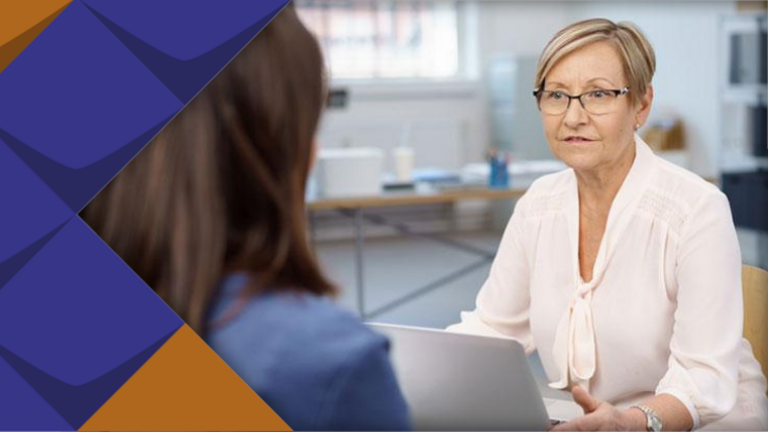 Eine Beratungssituation: Zwei Personen sitzen sich gegenüber und sprechen miteinander. 