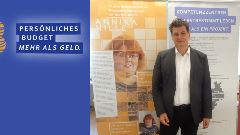 PB - Persönliches Budget - Mehr als Geld; Tobias Fischer, Jurist des KSL Düsseldorf, vor drei Elementen der Ausstellung